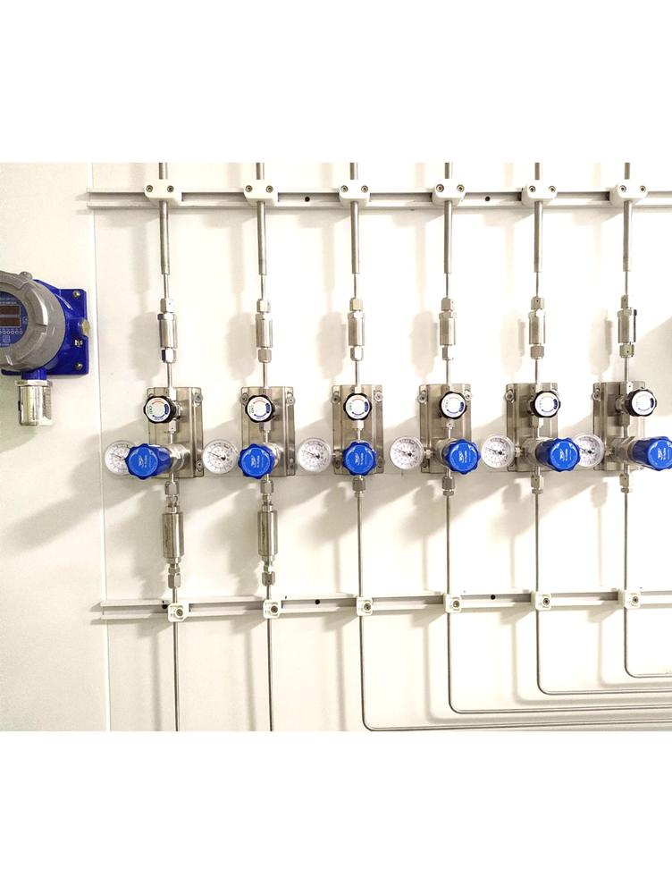 Stainless steel gas manifold with regulators and gauges installed in a laboratory